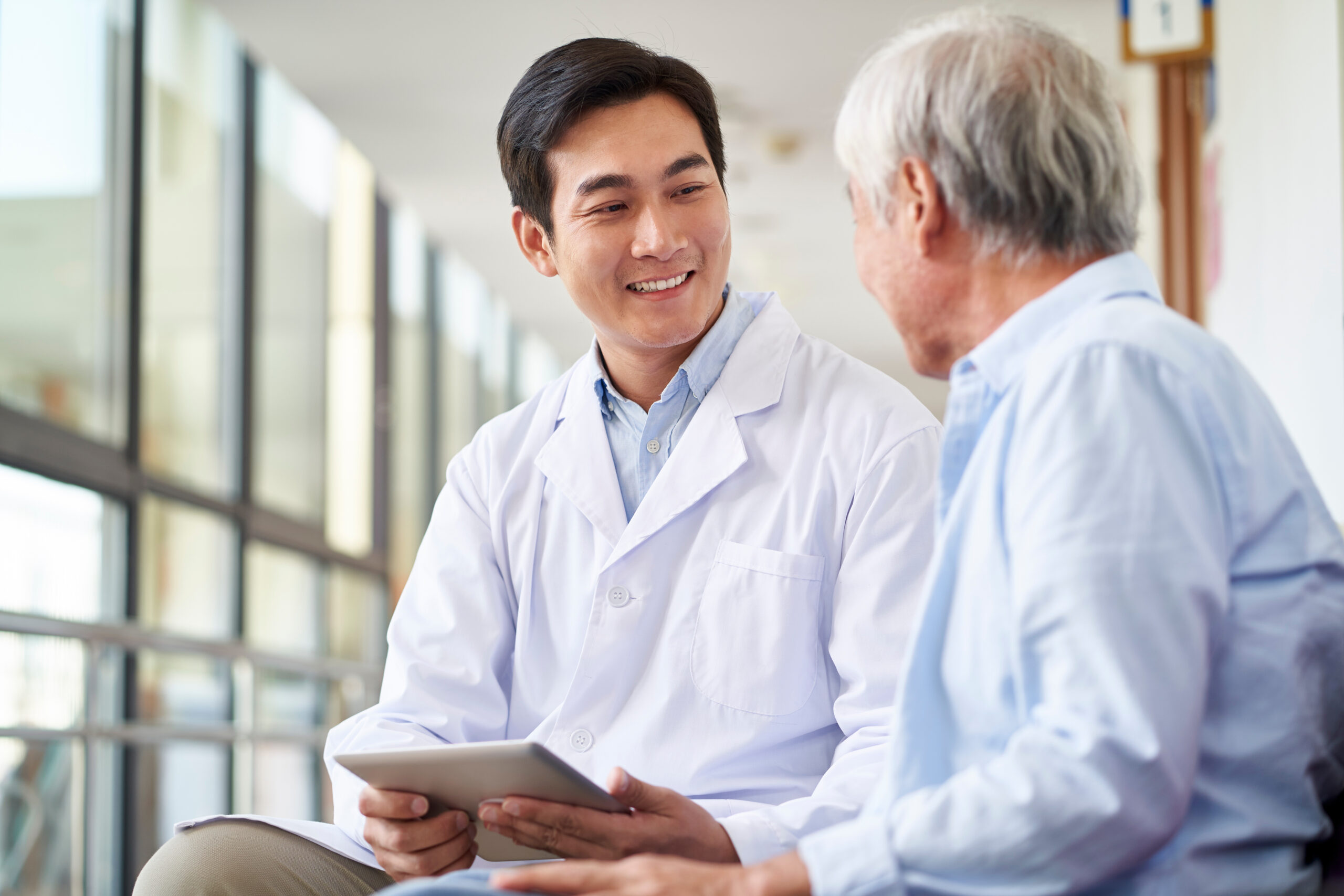 Friendly,smiling,young,asian,doctor,talking,and,explaining,test,result